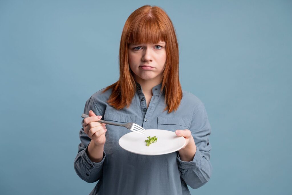 Δυσαρεστημένη γυναίκα που κρατάει ένα πιάτο με φαγητό